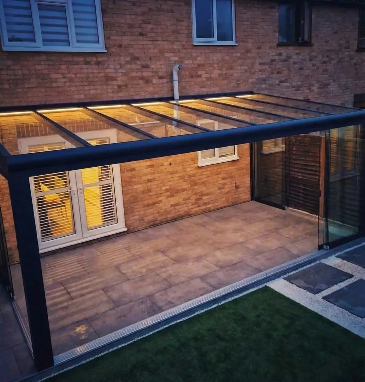 Black aluminium glass-roof veranda pergola with LED lighting over a patio — BlueCrest, Egypt